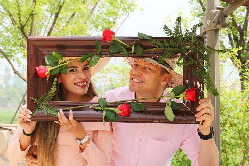 Mother and father smiling while looking through a frame, enjoying family moments