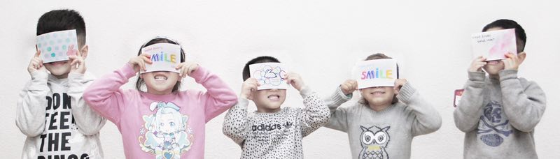 Child holding a sign that says 'Smile', spreading positivity and joy